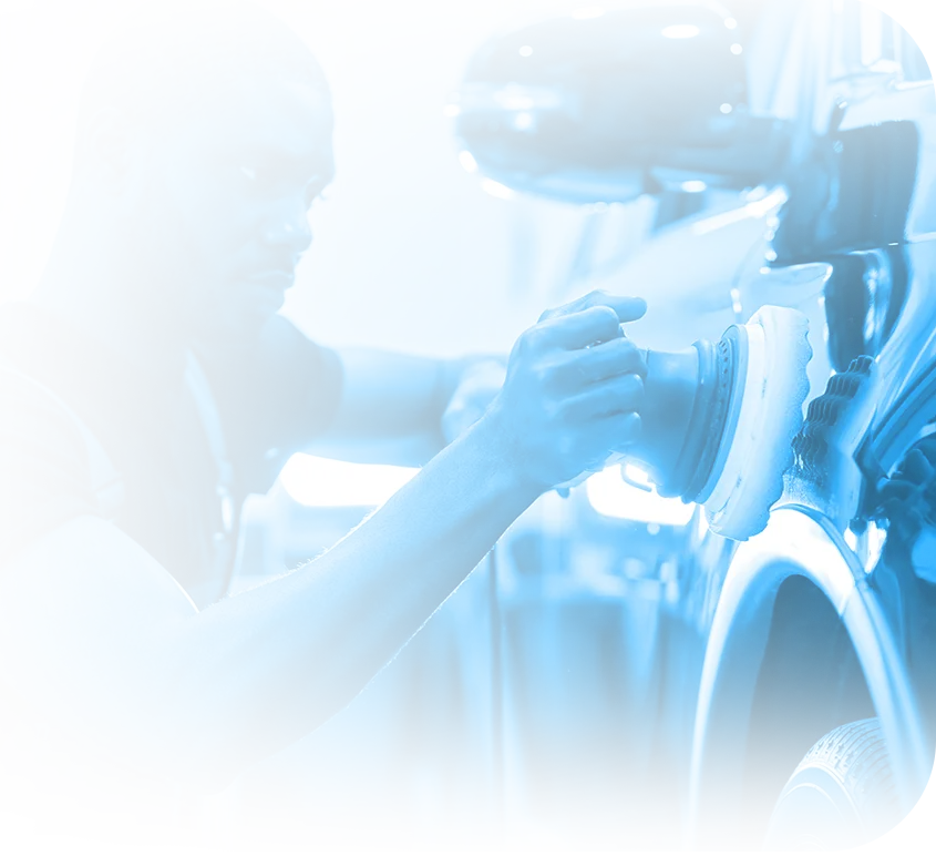 Professional detailer in Indianapolis buffing a dark car with a dual-action polisher for a mirror-like finish