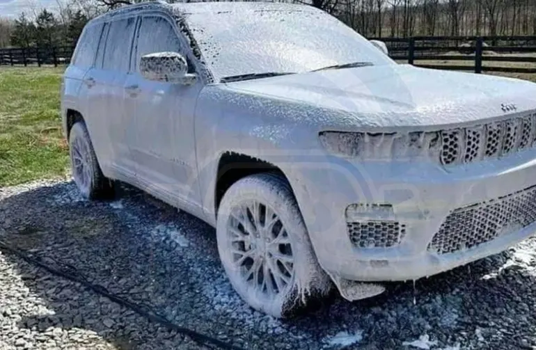 White Jeep Grand Cherokee covered in thick snow foam during mobile exterior detailing in Seattle
